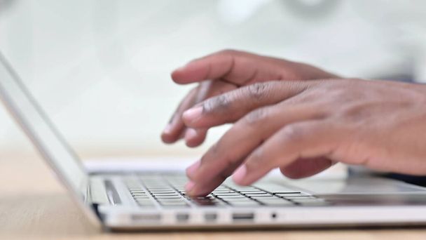 Vista lateral de los dedos africanos escribiendo en el ordenador portátil - Foto, imagen