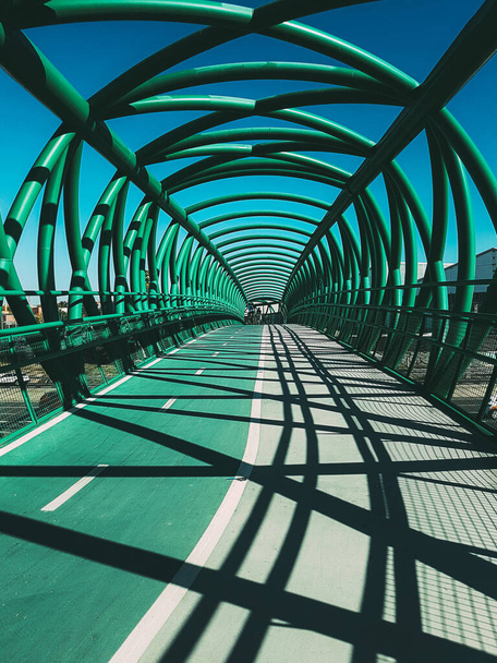 A vertical shot of a modern metal bridge in the blue sky background - Fotoğraf, Görsel