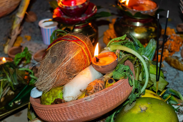 Високий кут зблизька вистрілив кокосові фрукти та інші молитовні пожертви на Чат Пуджі в індуїстській релігії з пахощами та лампою глиняного кадила. - Фото, зображення
