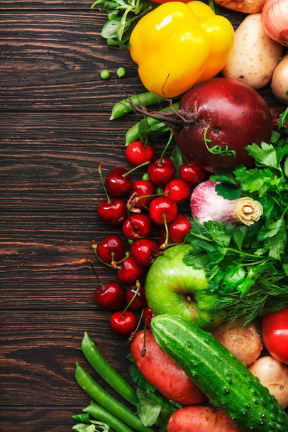 Zdrowe jedzenie. Asortyment świeżych warzyw ekologicznych latem, owoców i jagód na drewnianym tle stołu - Zdjęcie, obraz