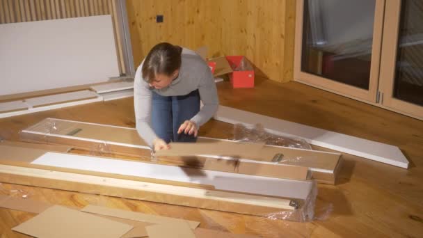 Bezárás: fiatal nő kibontja az ágykeret, miközben berendező az új hálószoba. - Felvétel, videó