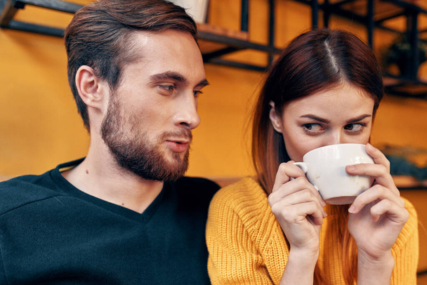 retrato de un hombre en un suéter y una mujer con una taza de café habitación interior - Foto, Imagen