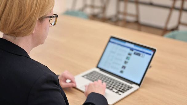 Vista trasera de la mujer de negocios usando el ordenador portátil, Desplazamiento - Foto, imagen