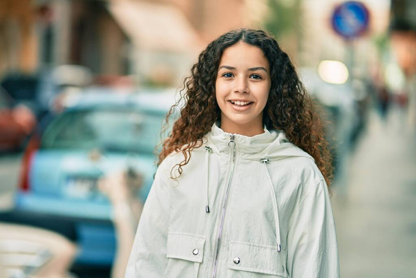 Ισπανίδα έφηβη χαμογελάει χαρούμενη που στέκεται στην πόλη.. - Φωτογραφία, εικόνα
