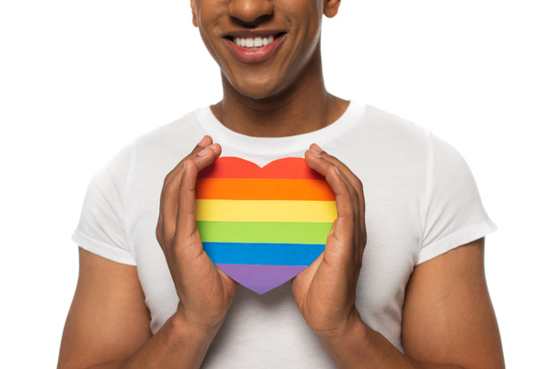 partial view of african american man holding lgbt colors paper heart isolated on white - Photo, Image