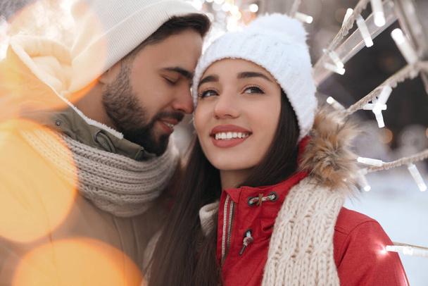 Happy young couple spending time together at winter fair. Christmas celebration - Foto, Imagem