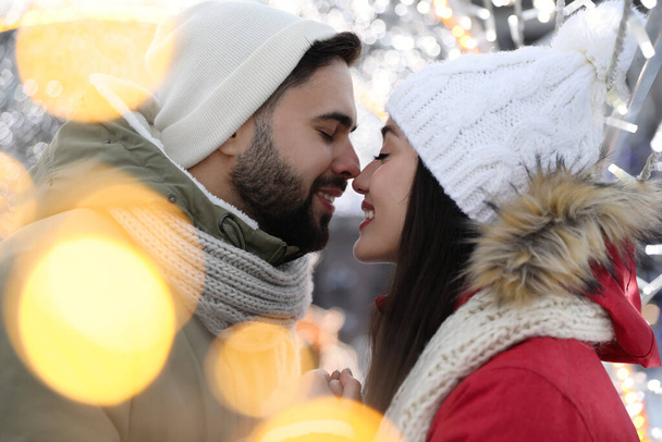Happy young couple spending time together at winter fair. Christmas celebration - 写真・画像