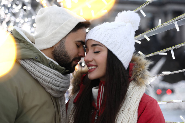 Happy young couple spending time together at winter fair. Christmas celebration - Foto, Imagem