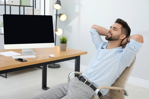 Young businessman relaxing in office chair at workplace - Foto, immagini