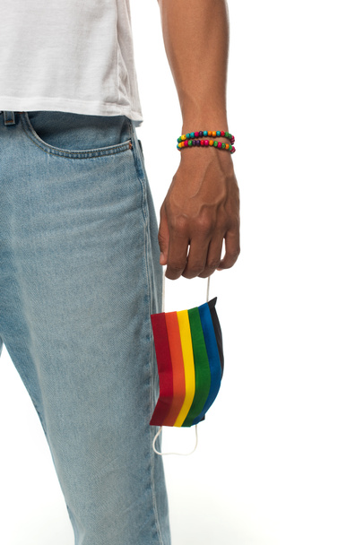 vista cortada do homem americano africano com pulseira e máscara médica em cores do arco-íris isolado no conceito branco, lgbt - Foto, Imagem