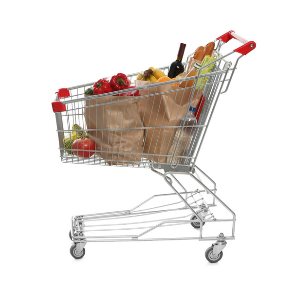Shopping cart full of groceries on white background - Photo, image