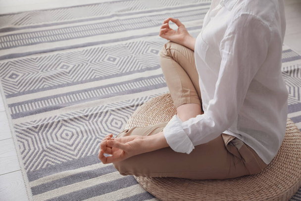 Woman meditating on wicker mat at home, closeup. Space for text - Fotoğraf, Görsel