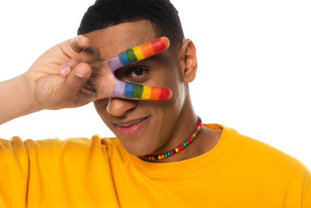 uomo afroamericano mostrando segno di vittoria con le dita dipinte in colori lgbt isolato su bianco - Foto, immagini
