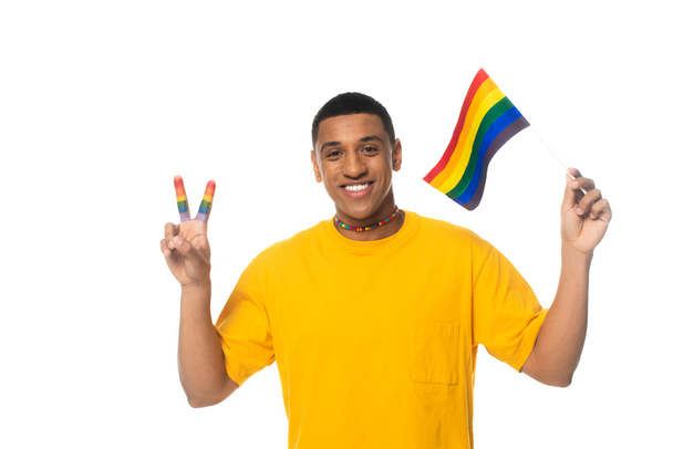 african american man holding lgbt flag and showing victory gesture isolated on white - 写真・画像