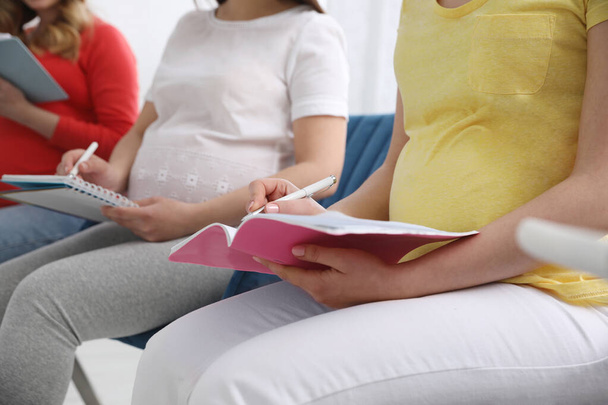 Group of pregnant women at courses for expectant mothers on blurred background, closeup - Fotografie, Obrázek