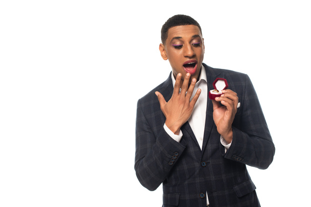 збуджений афро-американський гомосексуальний чоловік тримає ювелірну коробку з обручкою ізольовано на білому
 - Фото, зображення