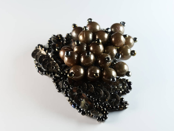Broche con perlas aisladas en negro, con diamantes, enfoque selectivo, DOF, macro, sobre fondo blanco - Foto, imagen