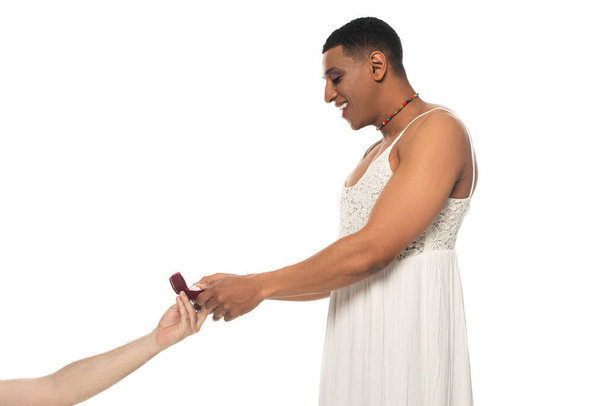 happy african american transgender taking wedding ring from man isolated on white - Foto, Imagem