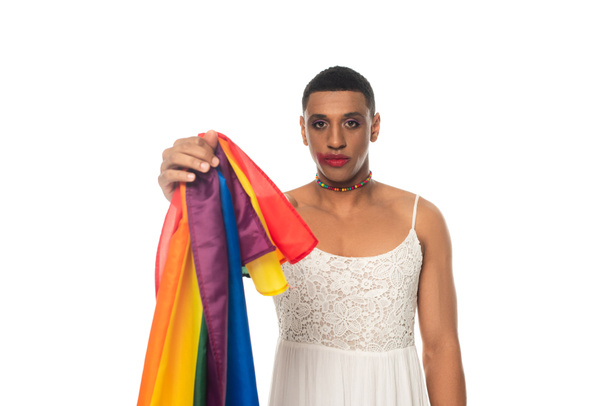 africano americano transexual hombre en vestido de fiesta mostrando lgbt bandera aislado en blanco - Foto, Imagen