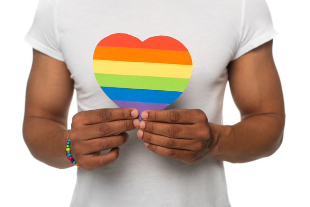 partial view of african american man showing lgbt colors paper heart isolated on white - Φωτογραφία, εικόνα