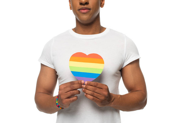 cropped view of african american man with bracelet and paper heart in lgbt colors isolated on white - Photo, Image