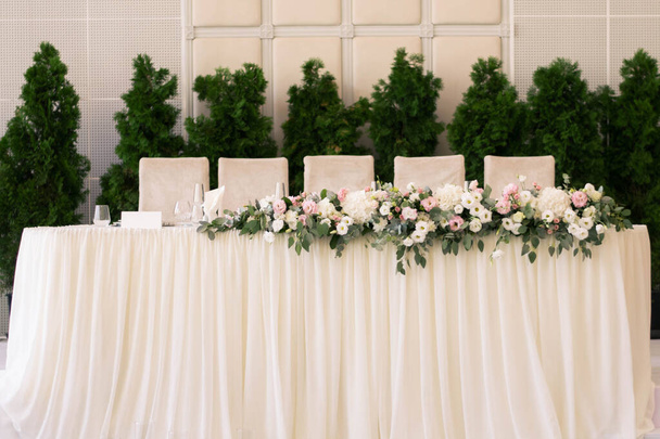 Główny stół na weselu z pięknymi kwiatami. Dzień ślubu. Dekoracje ślubne z różowymi kwiatami. - Zdjęcie, obraz