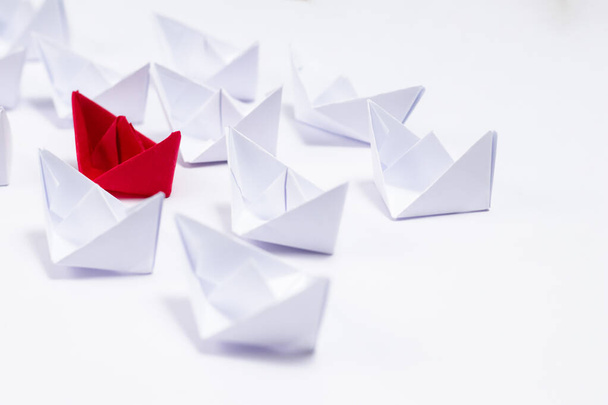  Un bateau en papier rouge entre des bateaux blancs montrant un concept unique et de leadership - Photo, image