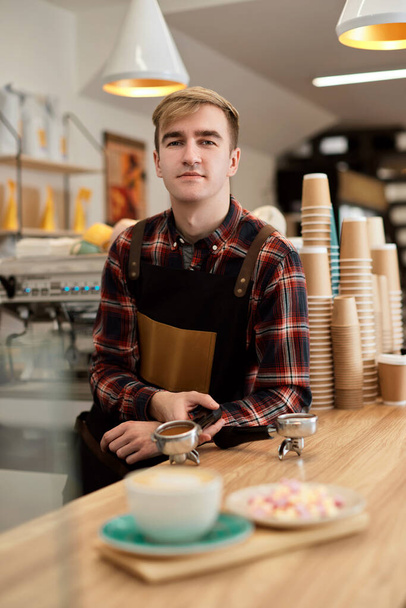 happy male waiter in apron in coffee shop - Photo, Image