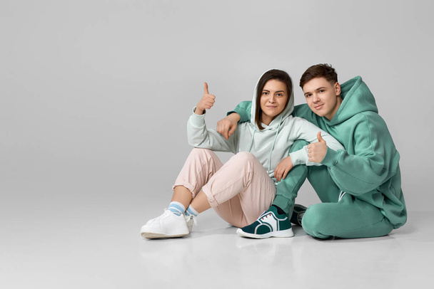 young couple wearing mint green casual hoodie - Zdjęcie, obraz
