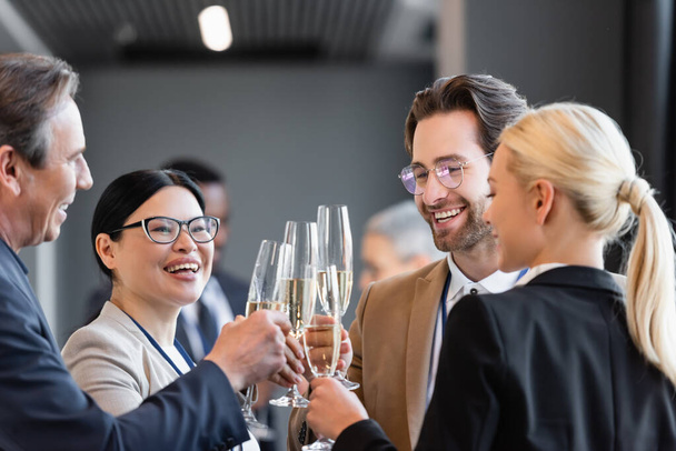 feliz interracial negócios pessoas clinking taças de champanhe durante a conferência - Foto, Imagem