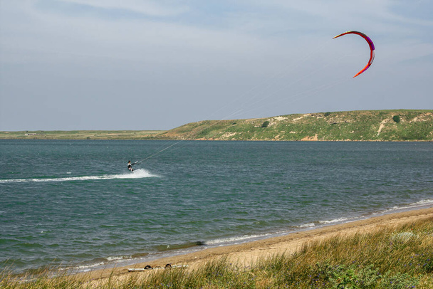 Άνθρωπος kite surfing (kite-boarding) στην Αλυκή (Tuz golu) κοντά στην παραλία της Κεφάλου στο νησί Gokceada (Ίμβρος), Canakkale, Τουρκία - Φωτογραφία, εικόνα