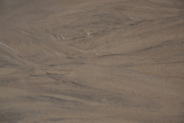Natuurlijke achtergrond. Zandbodem van de beek close-up. Een patroon in het zand geschilderd met water. - Foto, afbeelding