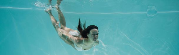 mladá žena v bílých plavkách potápění v bazénu, prapor - Fotografie, Obrázek