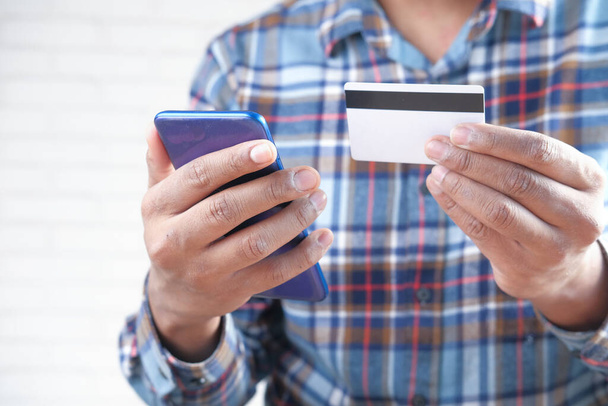 手押し式クレジットカードとスマートフォンのオンラインショッピング  - 写真・画像