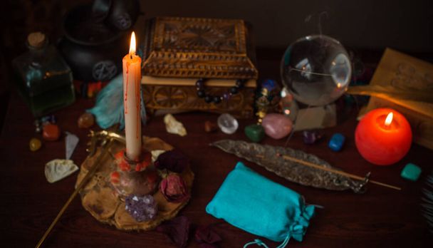 Una adivina, cosas de brujas en una mesa, velas y objetos adivinos. El concepto de adivinación, astrología y esoterismo - Foto, imagen