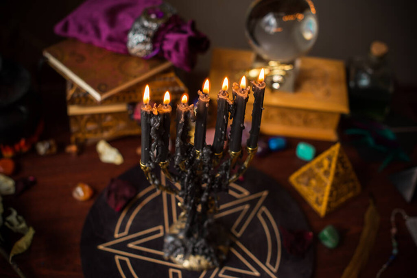Una adivina, cosas de brujas en una mesa, velas y objetos adivinos. El concepto de adivinación, astrología y esoterismo - Foto, imagen