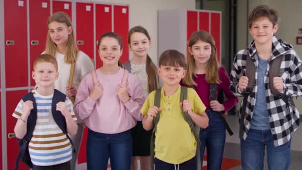 Video ryhmä hymyileviä lapsia seisoo koulun käytävällä. Laukaus punaisella heliumkameralla 8K. - Materiaali, video