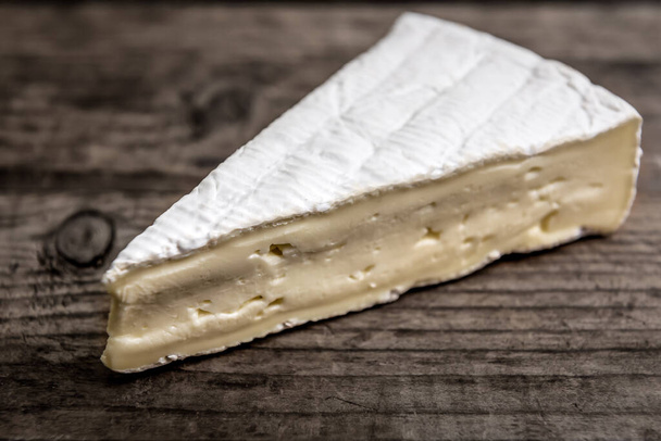 triangle of fresh brie cheese on wooden background - Foto, Imagem