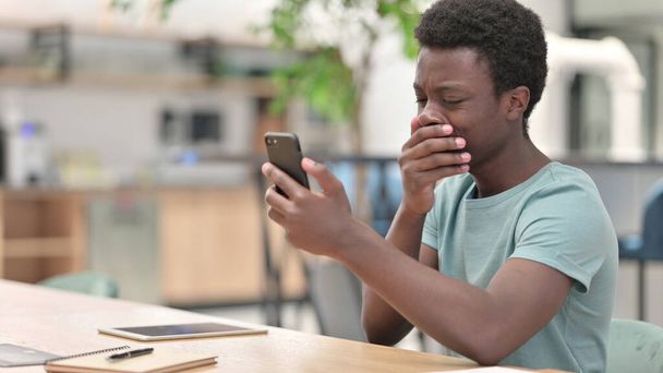 Расстроенный молодой африканский человек, потерявший смартфон - Фото, изображение