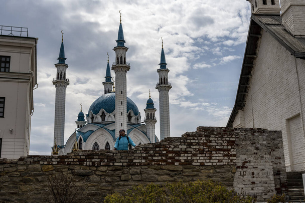 Mavi ceketli kadın turist Kazan 'daki eski Kremlin manzarasını keşfediyor. - Fotoğraf, Görsel