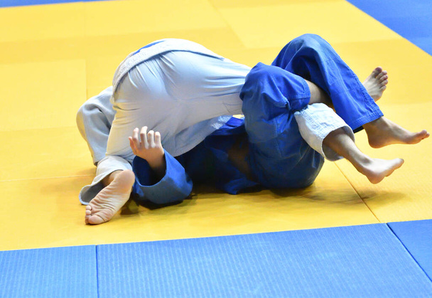 Two Boys judoka in kimono compete on the tatami  - Photo, Image