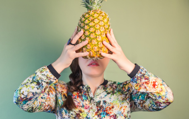 Fashion girl holding pineapple in front of face - Foto, Imagen