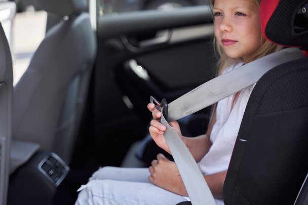 Little girl doing by car in safe seat - Foto, Imagem