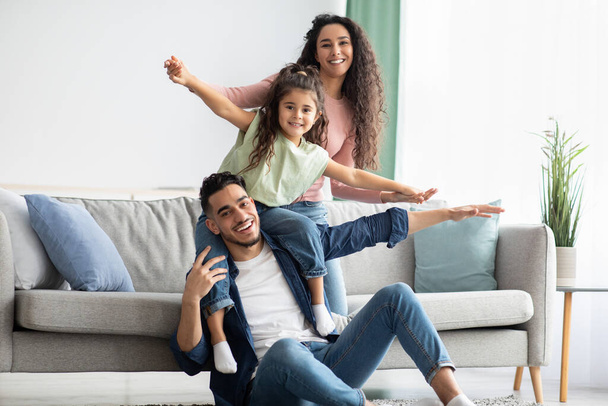 Portrait Of Happy Middle Eastern Parents Bonding With Their Child At Home - Photo, image