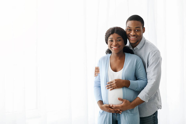 Boldog fekete pár vár baba, pózol a fehér háttér - Fotó, kép
