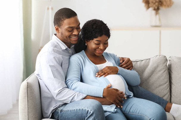 Amar a la pareja embarazada disfrutando del tiempo juntos en casa - Foto, Imagen