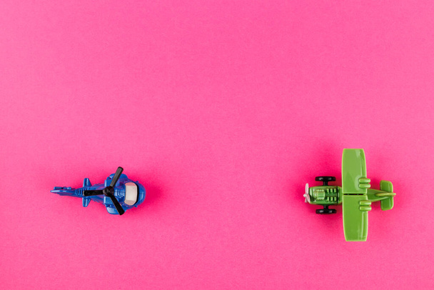 Small plastic airplane and helicopter with copy space on pink background. Toys. - Photo, image