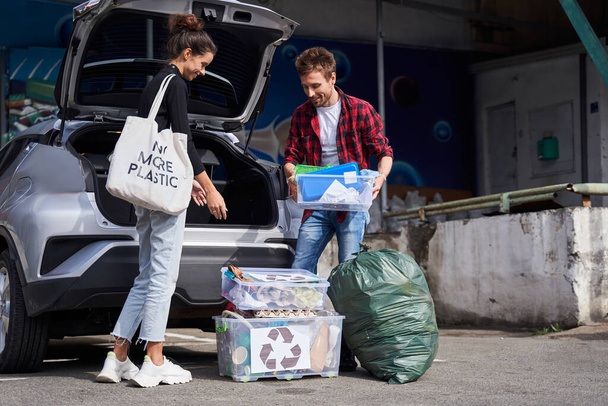 Family taking the waste boxes out of the trunk - Foto, immagini