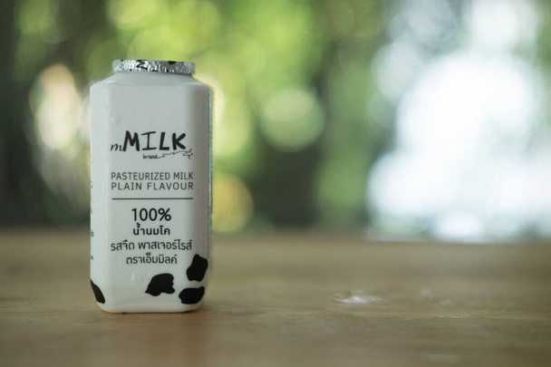 Samut Prakan, Thailand - 5. Mai 2021: Produkt Mmilk, pasteurisierte Milch ebenes Aroma Holztisch auf Naturhintergrund setzen - Foto, Bild