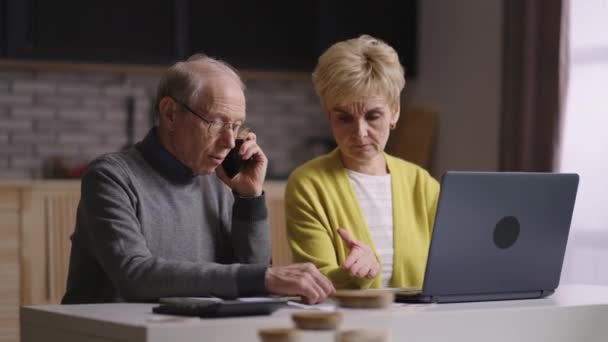 staří důchodci konzultují telefonicky s finančním nebo pojišťovacím poradcem, vypočítávají rozpočet společně - Záběry, video